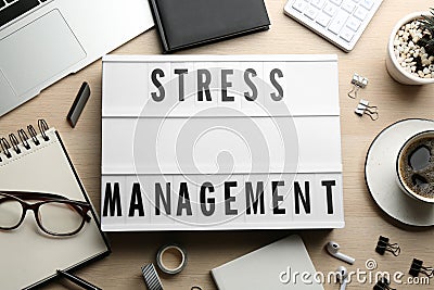 Flat lay composition of lightbox with phrase Stress Management on wooden table Stock Photo