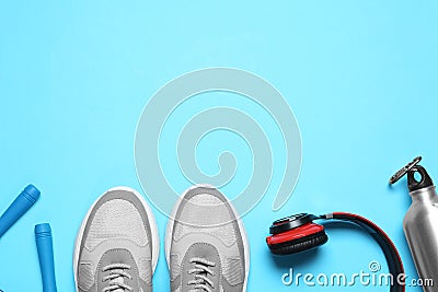 Flat lay composition with man`s sneakers and fitness items on blue background, space for text Stock Photo