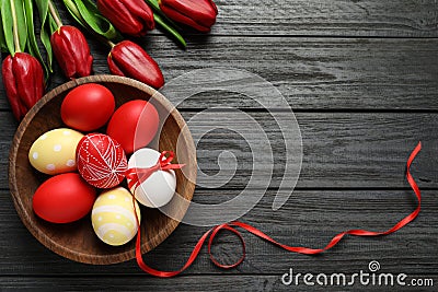 Flat lay composition of painted Easter eggs and flowers on wooden table, space for text Stock Photo