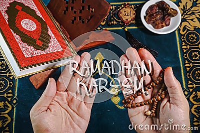 Flat lay composition of Qoran, Dates and tasbih rosary beads on top of a sajadah praying mattress Stock Photo
