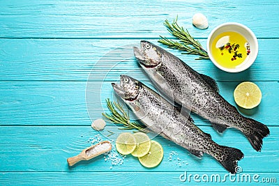 Flat lay composition with raw cutthroat trout fish on blue wooden table, space for text Stock Photo