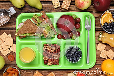 Flat lay composition with serving tray, tasty healthy food on wooden table. School dinner Stock Photo