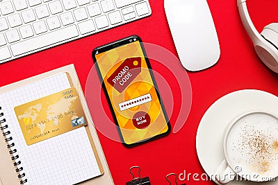 Flat lay composition of smartphone with activated promo code on red table Stock Photo