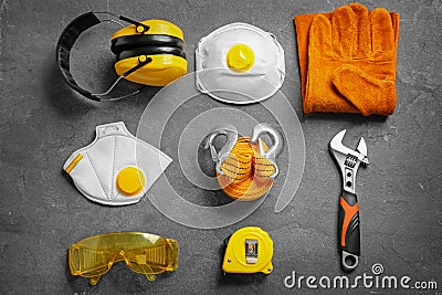 Flat lay composition with tools and safety equipment on grey Stock Photo