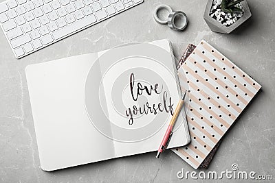 Flat lay composition with words LOVE YOURSELF written in notebook Stock Photo