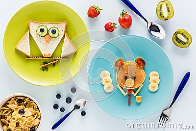 Flat lay with creatively styled children`s breakfast with berries and kiwi Stock Photo