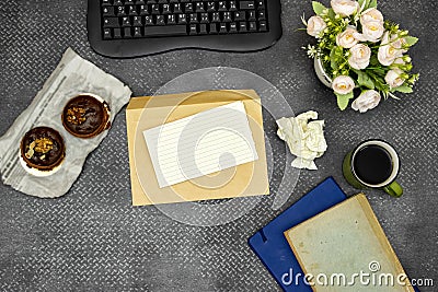 Flat lay desktop, Modern computer keyboard, flower`s pot and crashed paper and empty card on envelope on grunge background Stock Photo