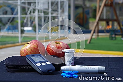 Diabetic set up glucometer and apple on a table onrk a pa Stock Photo