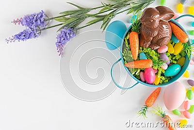 Flat lay Easter background with mini carrots, lavender, Easter eggs, and chocolate bunny Stock Photo