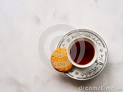 Flat lay of English tea in a porcelain china cup with a digestive biscuit Stock Photo