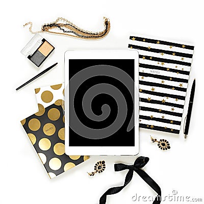 Flat lay fashion feminine home office workspace with tablet, stylish black gold notebooks, cosmetics and jewelry on white backgrou Stock Photo