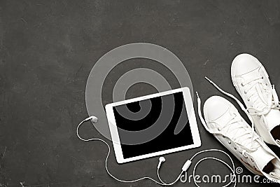 Flat lay Of fashion White Sneakers On black Background with phone, headphones, tablet, copy book Stock Photo