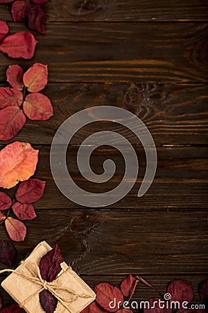 Flat lay frame of autumn crimson leaves and gift boxes on a dark Stock Photo