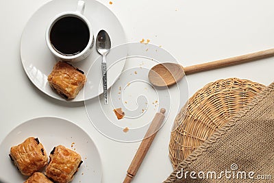 Flat lay of fresh and relaxed settting of black coffee and Pan Au Chocolate French inspired afternoon tea arrangement with clean Stock Photo