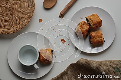 Flat lay of fresh and relaxed settting of black coffee and Pan Au Chocolate French inspired afternoon tea arrangement with clean Stock Photo