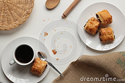 Flat lay of fresh and relaxed settting of black coffee and Pan Au Chocolate French inspired afternoon tea arrangement with clean Stock Photo