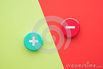 Flat lay of green plus and red minus symbol plastic button on green and red background with copy space. Concept of difference Stock Photo