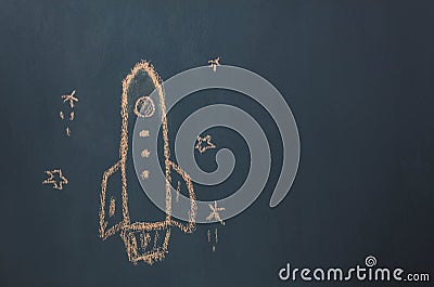 Flat lay Handmade drawing rocket ship launch / take off to the space with star on the blackboard by chalk board. Stock Photo