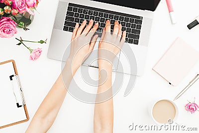 Flat lay home office desk. Woman workspace with female hands, laptop, pink roses bouquet, accessories, diary. Top view. Girl worki Stock Photo