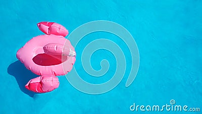 Flat lay inflatable pink flamingo swims in clear blue azure pool water. Summer concept of refreshment after the heat Stock Photo