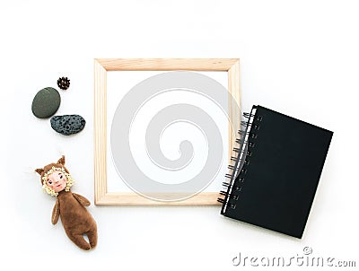 Flat lay mock up, top view, wooden frame, toy squirrel, stones, black note pad. Interior layout, square poster mockup, wood frame Stock Photo