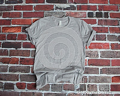 Flat lay mockup of gray tee shirt on brick background Stock Photo