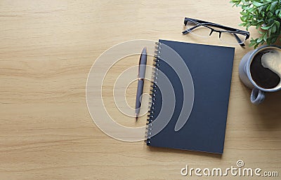 Flat lay notebook, eyeglasses, coffee cup and potted plant on wooden table Stock Photo