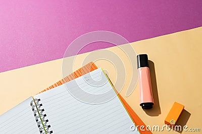 Flat lay of notebooks and highlighter with copy space on pink and yellow background Stock Photo