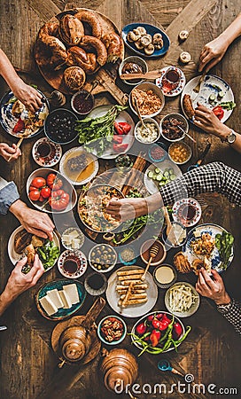Flat-lay of peoples hands holding traditional turkish breakfast cuisine food Stock Photo