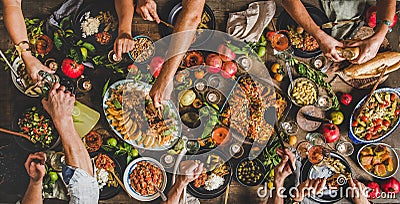 Flat-lay of peoples hands and Turkish foods over rustic table Stock Photo