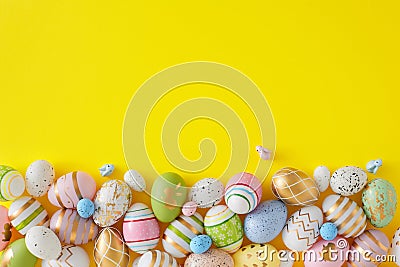 Flat lay photo of multicolored eggs and cute rabbits on yellow background Stock Photo