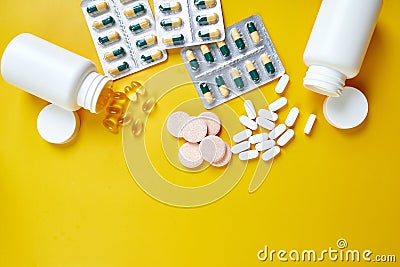 Flat lay of pills, fish oil, vitamins on yellow background Stock Photo