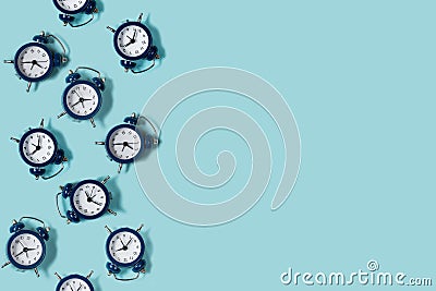 Flat lay retro beautiful new alarm clock on blue color background. Pattern. Stock Photo