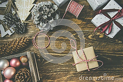 Flat lay on rustic aged wood background, Christmas or New Years gits wrapped in craft brown white paper. Ribbon,twine,pine cones Stock Photo