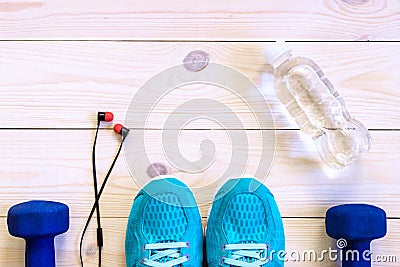 Flat lay shot of Sport equipment, shoes, water, earphone on wooden background. Stock Photo