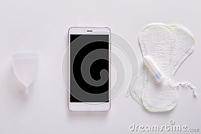 Flat lay of smartphone, tampon, hygiene menstrual napkins laying over white background, menstrual cycle tracking, choosing better Stock Photo