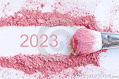 Flat lay of smear of crushed pink cosmetics with 2023 number, copy space, top view. New year concept Stock Photo