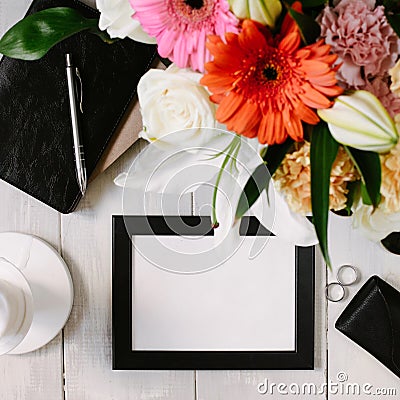 Flat lay styled framed composition with blank frame, sunglasses, saturated bouquet, black leather notebook and parfume Stock Photo