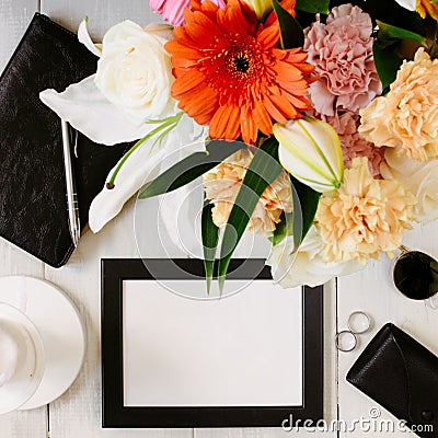 Flat lay styled framed composition with blank frame, sunglasses, saturated bouquet, black leather notebook and parfume Stock Photo
