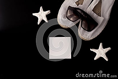 Flat lay of summer and beach holiday. Starfish, white espadrilles, white letterhead in black background. Concept of travel Stock Photo