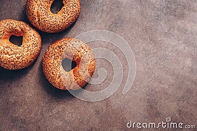 Flat lay three bagels with sesame on a dark rustic background. Top view, copy space Stock Photo