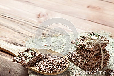 Flat lay top view crunchy flax seed crispbread with dry vegetable and linseed spoon on wooden rustic background with Stock Photo