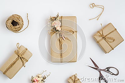 Flat lay top view gift wrapping composition. homemade wrapped present boxes, decoration and tools on white background for Stock Photo