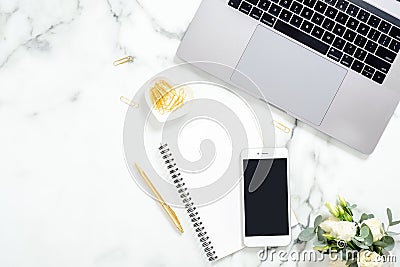 Flat lay, top view modern office table desk. Workspace with laptop computer, smartphone with blank screen, diary, flowers and Editorial Stock Photo