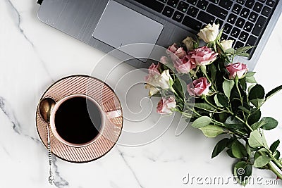 Flat lay, top view office table feminine desk. workspace with laptop, cup of cofee and bouquet pink roses.Mother`s day, birthday Stock Photo