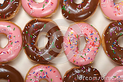 Flat lay top view of strawberry and chocolate frosted donuts with sprinkles Stock Photo