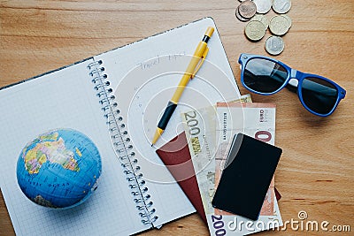 Flat lay travel concept with coins, cards, mobile phone, globe a Stock Photo