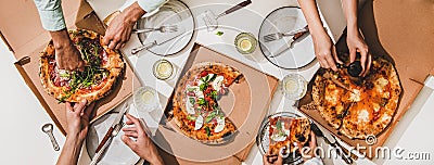 Flat-lay of various pizzas, lemon drinks and peoples hands Stock Photo