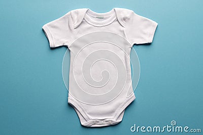 Flat lay of white baby grow with copy space on blue background Stock Photo