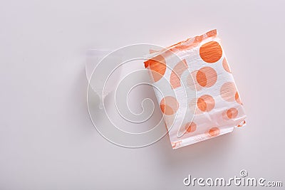 Flat lay of white menstrual cup and couple of packed hygiene pads being isolated over white background. Menstrual cap being eco Stock Photo